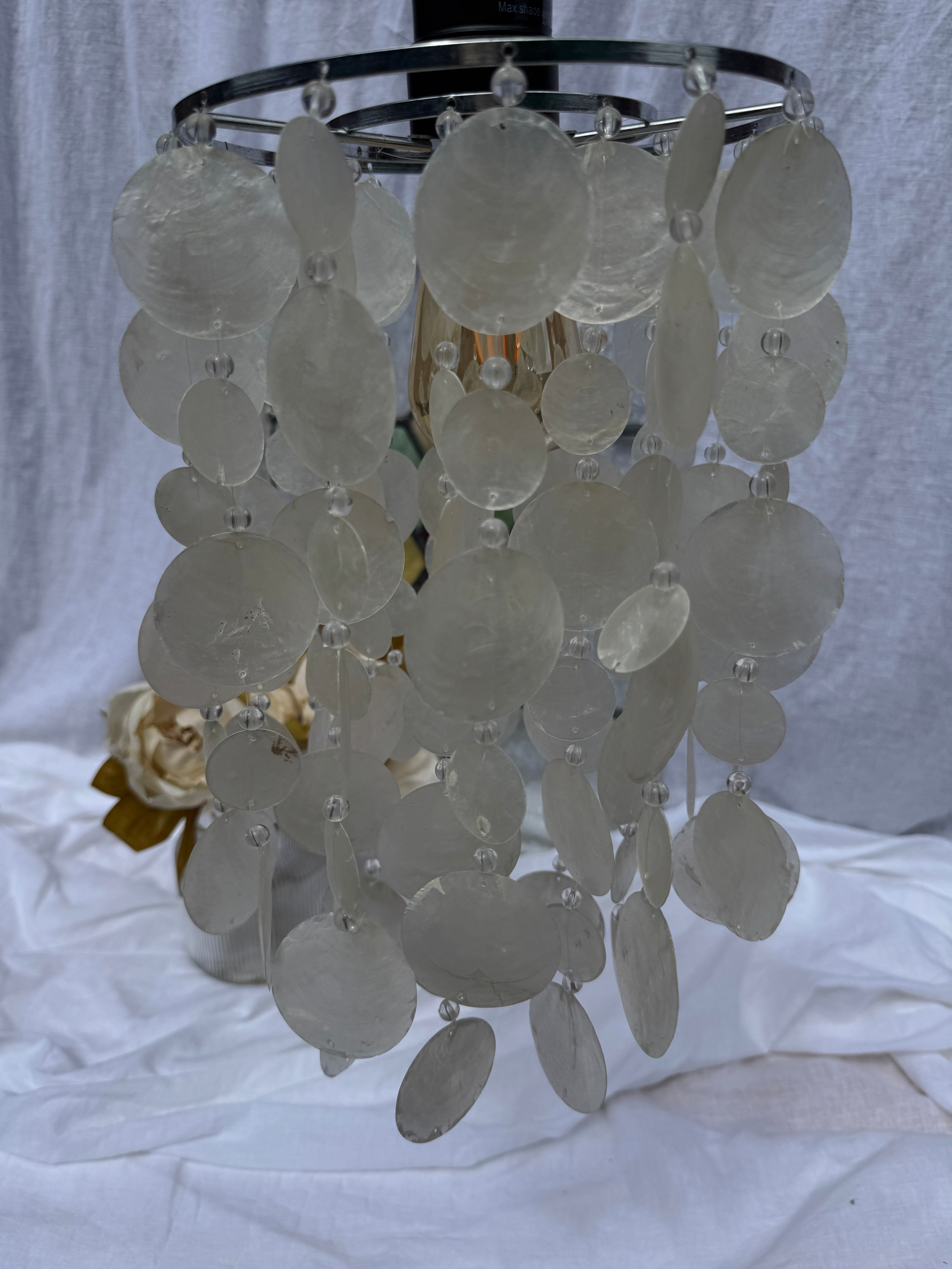 Decorative chandelier with circular glass panels on a white background